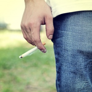 Toned Photo of Man hold a Cigarette in the Hand closeup outdoor