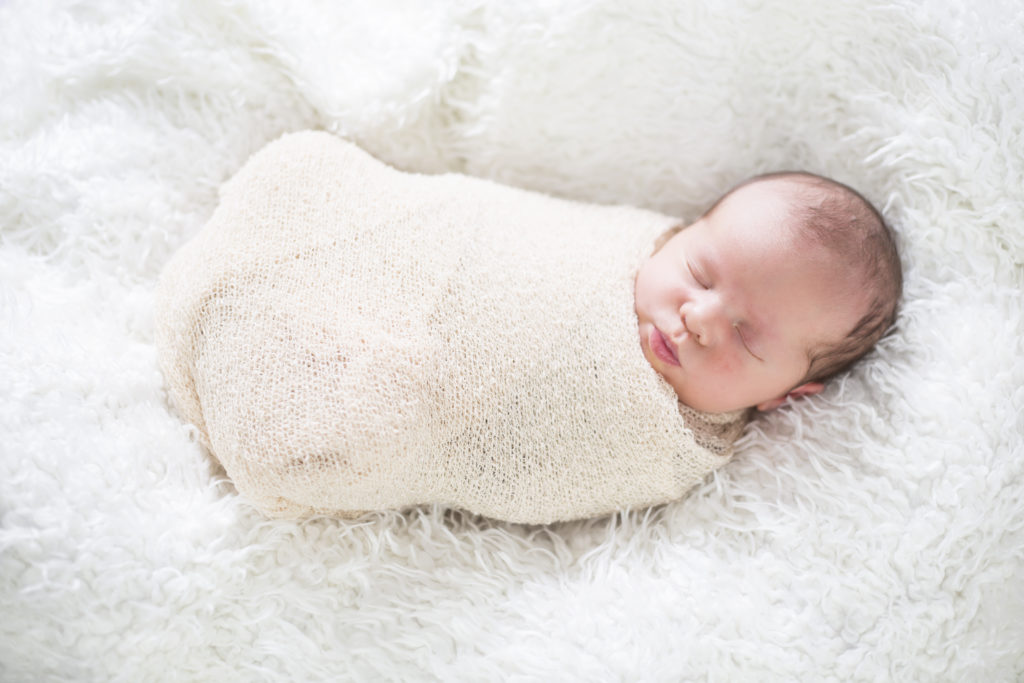 Viele Eltern pucken ihre Kinder, um diesen ein wohliges Gefühl zu geben und sie zu beruhigen. Eine Kinderärztin warnt jedoch vor möglichen Schädigungen durch das Einwickeln. (Bild: StefanieB./fotolia.com)