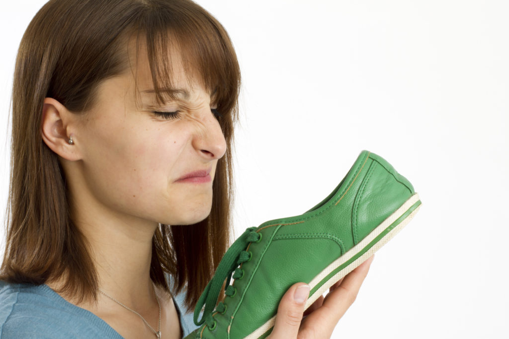 junge Frau riecht an Schuh