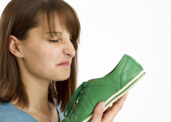 Junge Frau riecht an Schuh