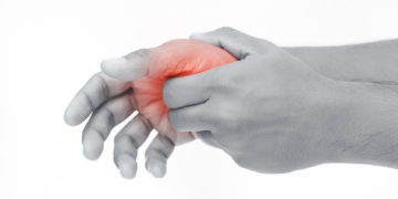 Daumenschmerzen können zum Beispiel als punktueller Schmerz im Bereich des Daumensattelgelenks oder als ein heftiges Ziehen im ganzen Finger wahrgenommen werden. (Bild: Adiano/stock.adobe.com)
