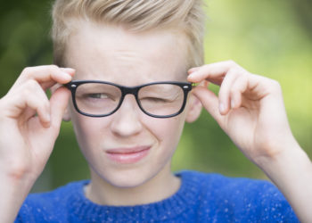 Junge mit Brille blinzelt auf einem Auge!