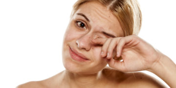 Frau reibt sich das Auge