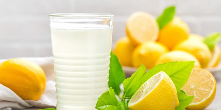 Frische Zitronen und ein Glas Zitronensaft