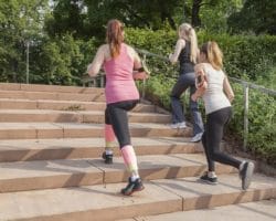 Drei Frauen laufen eine Treppe im Freien hoch