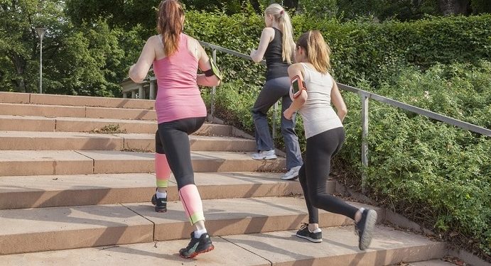 Drei Frauen laufen eine Treppe im Freien hoch