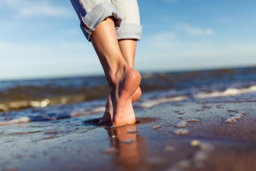 Barfuß am Strand entlang laufen