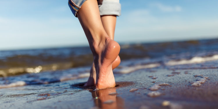 Barfuß am Strand entlang laufen