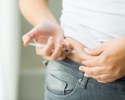 Frau spritzt sich Insulin.