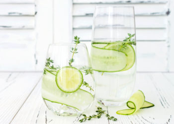 Zwei Gläser Wasser mit Limetten- und Gurkenscheiben