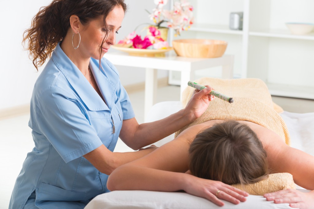 Alternative medicine therapist doing moxa treatment on her client