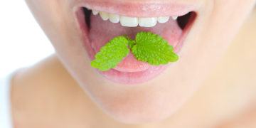 Das Lutschen von Minze ist ein bewährtes Hausmittel gegen Mundgeruch. Neben dem frischen Aroma bindet das enthaltene Chlorophyll unangenehme Gerüche. (Bild: benik.at/stock.adobe.com)