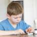 Young boy with diabetes measuring blood sugar.