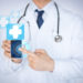 close up of male doctor holding smartphone with medical app