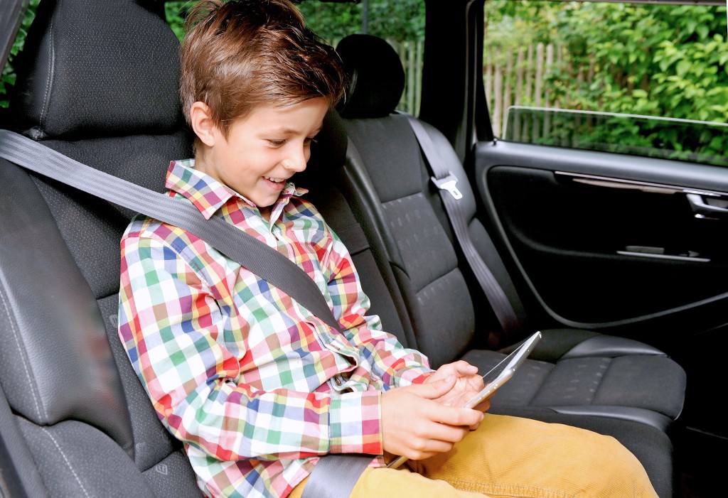 Kind mit Tablet-Computer im Auto