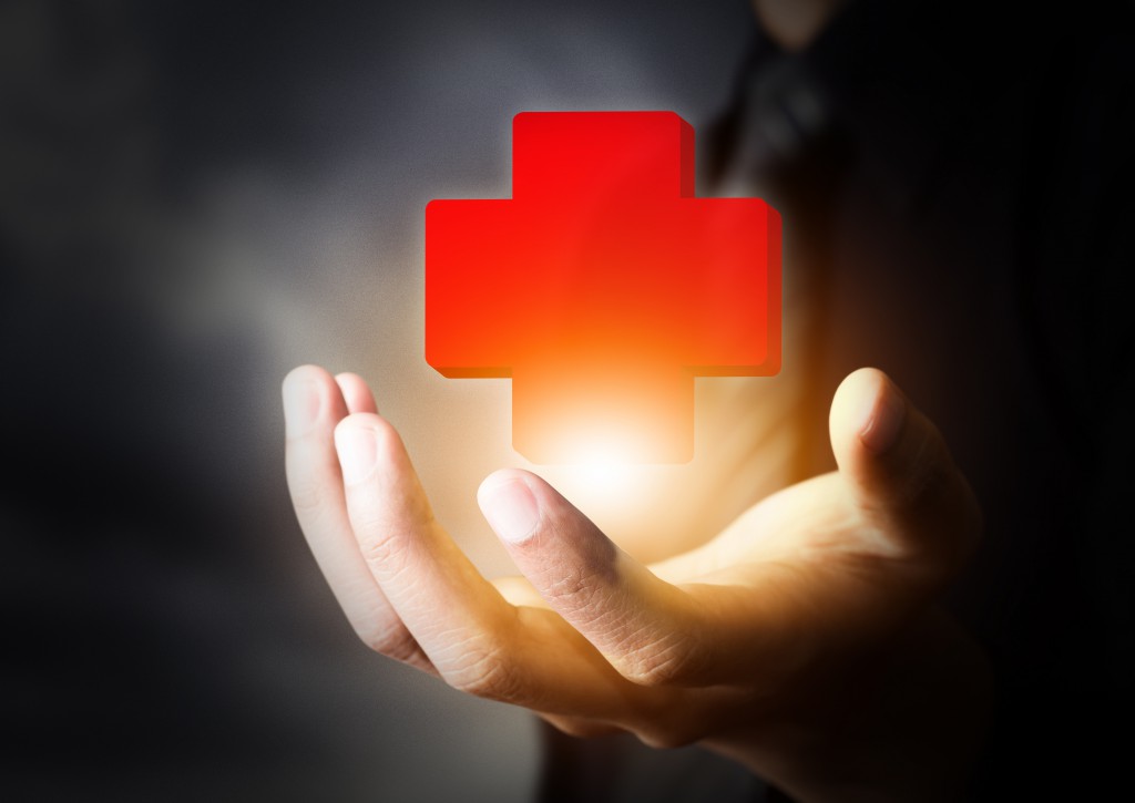 Hand holding First Aid icon, insurance concept