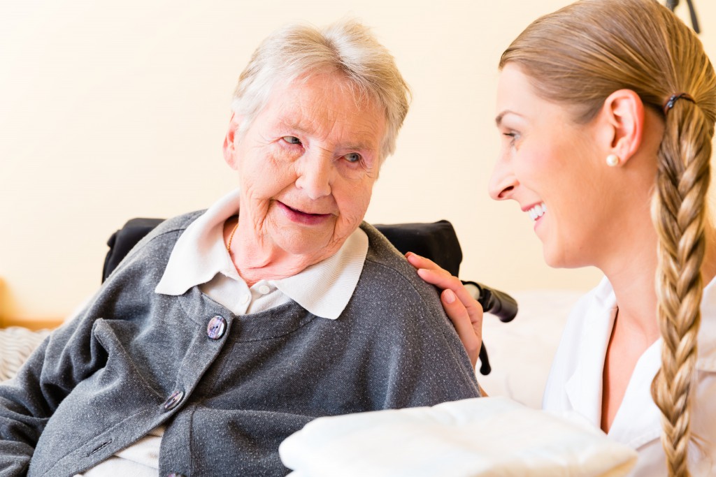 Nurse bringing supplies to senior woman in retirement home