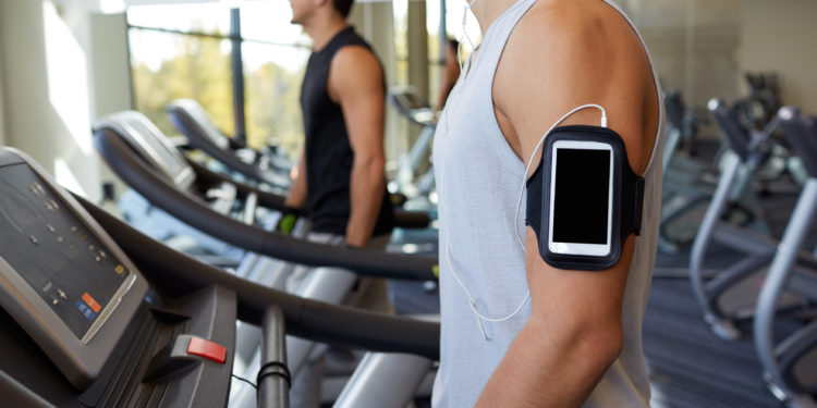 Zwei Männer laufen auf Laufbändern in einem Fitness-Studio.