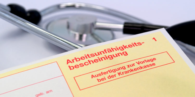 Eine Arbeitsunfähigkeitsbescheinigung vor einem Stethoskop