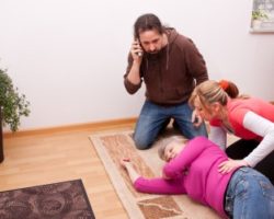 Zwei Personen leisten erste Hilfe bei einer älteren Frau