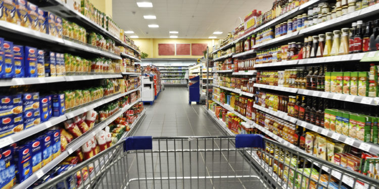 Mit einem Einkaufswagen durch den Supermarkt