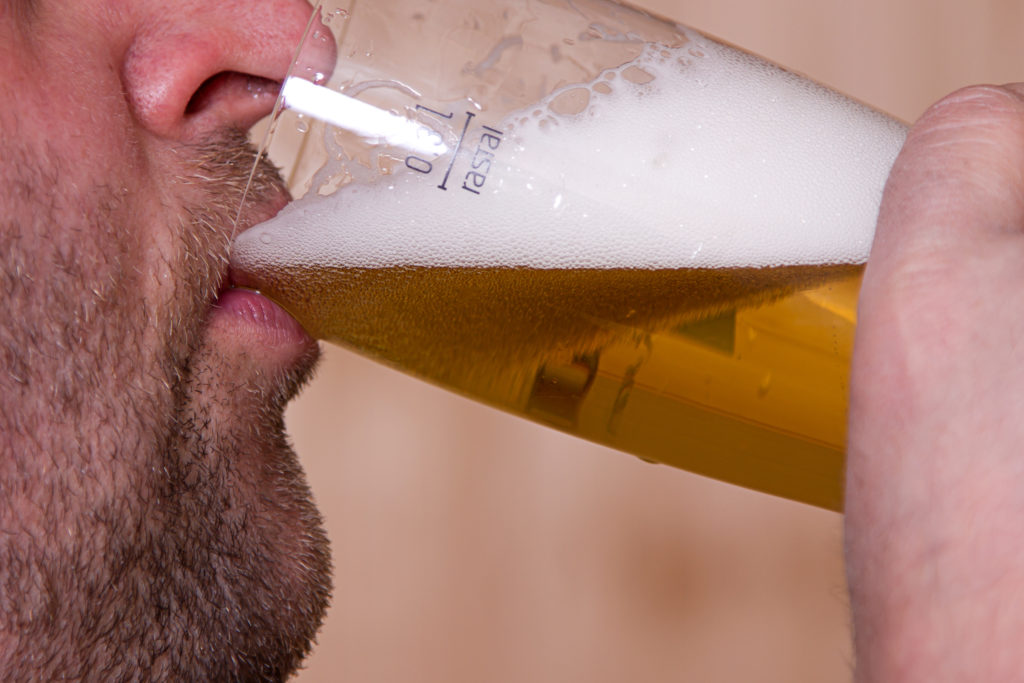 Mann trinkt Bier aus einem Glas