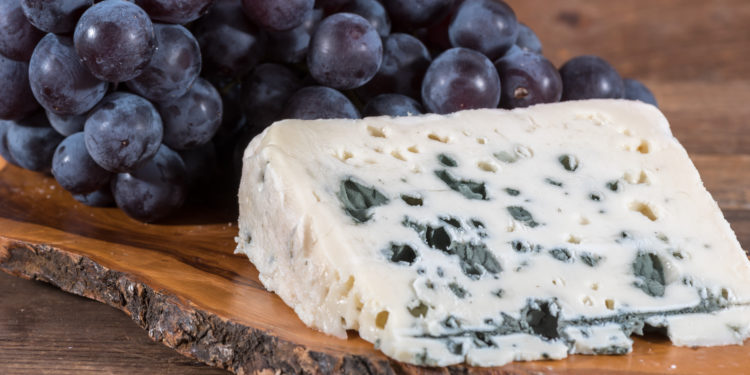 Blauschimmelkäse und blaue Trauben auf einem Brett