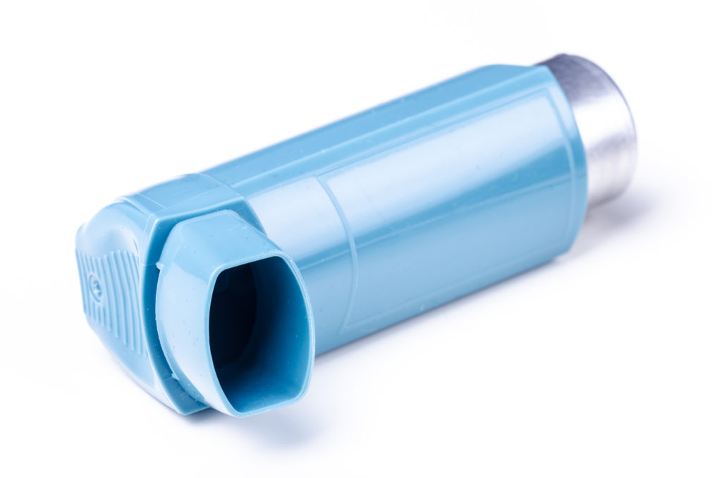 Turquoise asthma inhaler on white background with metal bottle