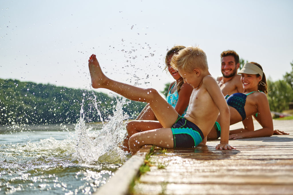 Mehrere Mitglieder einer Familie plantschen im Wasser