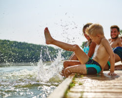 Mehrere Mitglieder einer Familie plantschen im Wasser