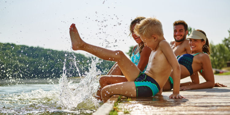 Mehrere Mitglieder einer Familie plantschen im Wasser