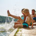 Mehrere Mitglieder einer Familie plantschen im Wasser