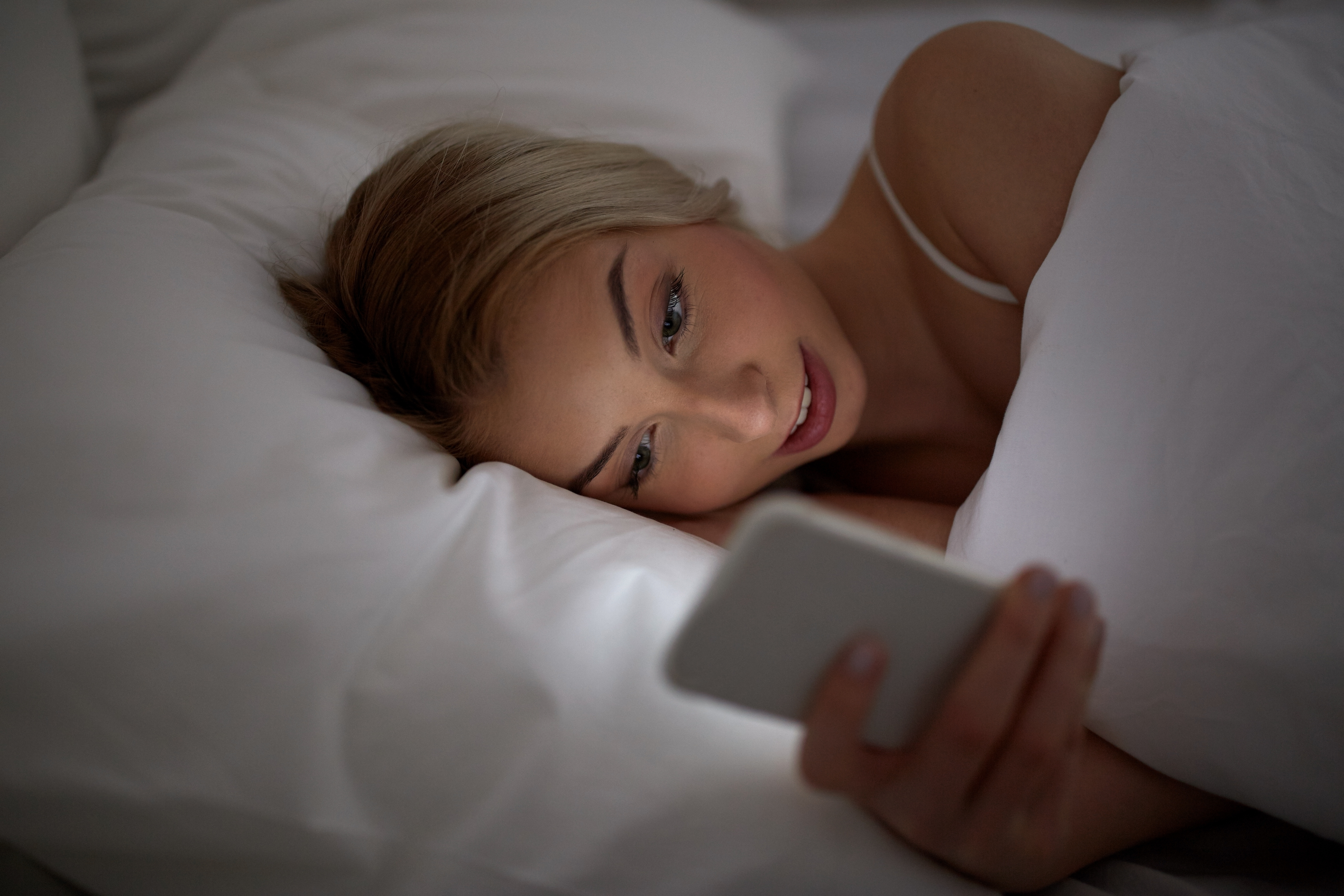 К чему снится телефон во сне женщине. Смартфон на кровати. Женщины на кровати с смартфоном. Девушка со смартфоном в постели. Девушка с мобильником в постели.