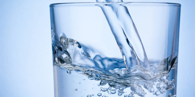 Wasser wird in ein Glas gegossen