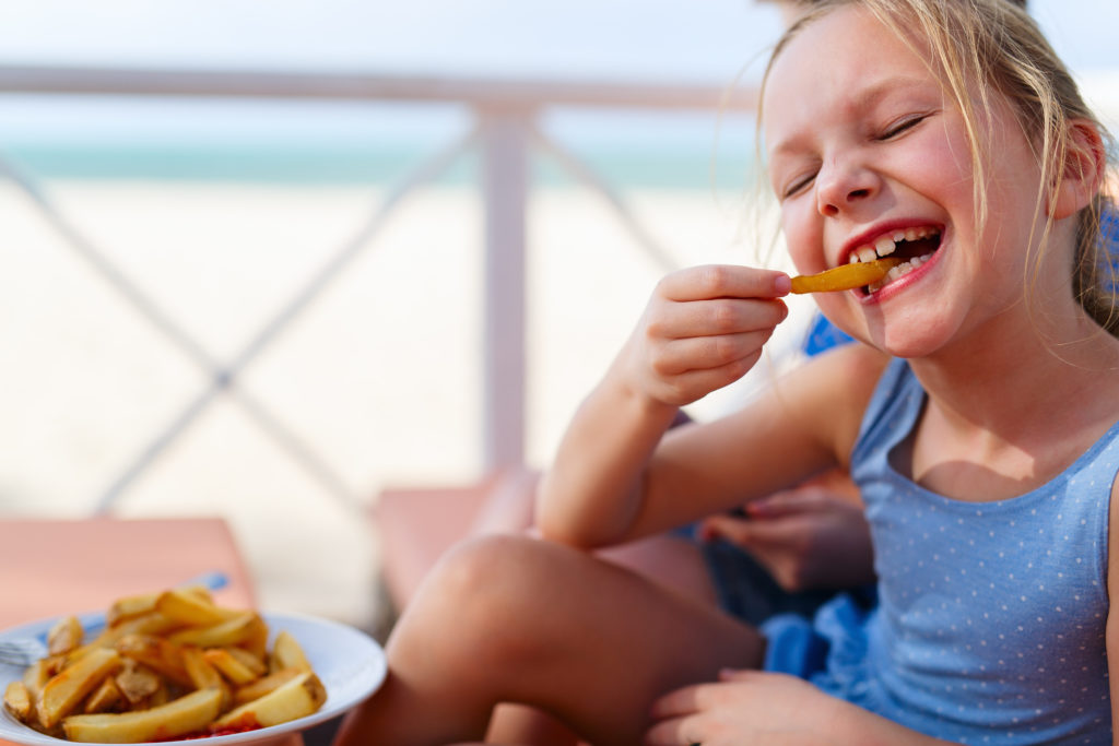 Kindern, die sich gerade Pommes oder ein Eis gegönnt haben, wird oft gesagt, dass sie mit dem Schwimmen warten müssen, weil es gefährlich ist, mit vollem Magen ins Wasser zu gehen. Was ist an der Behauptung dran? (Bild: BlueOrange Studio/fotolia.com)