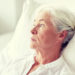 medicine, age, health care and people concept - senior woman patient lying in bed at hospital ward