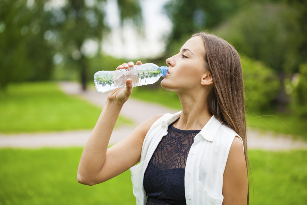 Frau trinkt Wasser aus der Flasche