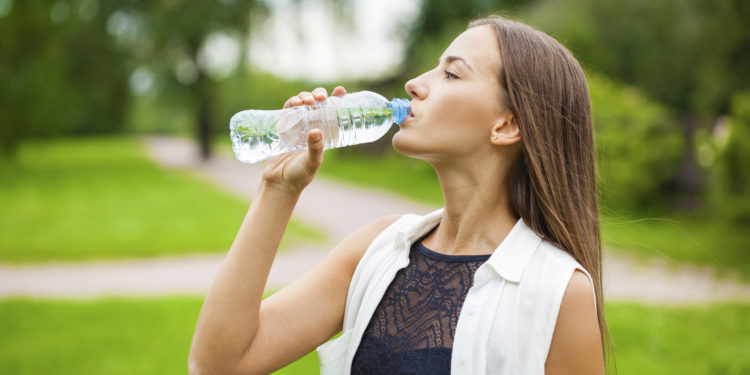 Frau trinkt Wasser aus der Flasche