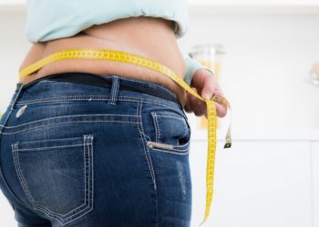 Übergewichtige Person misst Bauchumfang