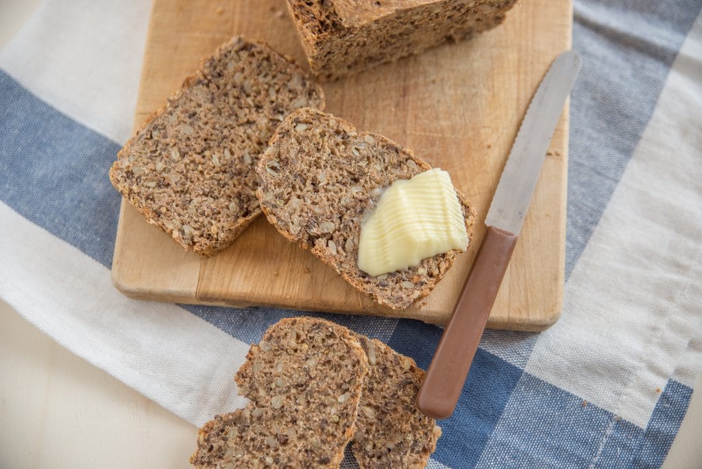 Mehrere Scheiben Brot, eine davon mit Butter