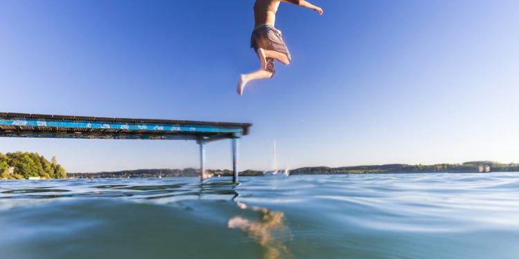 Junge springt in einen See