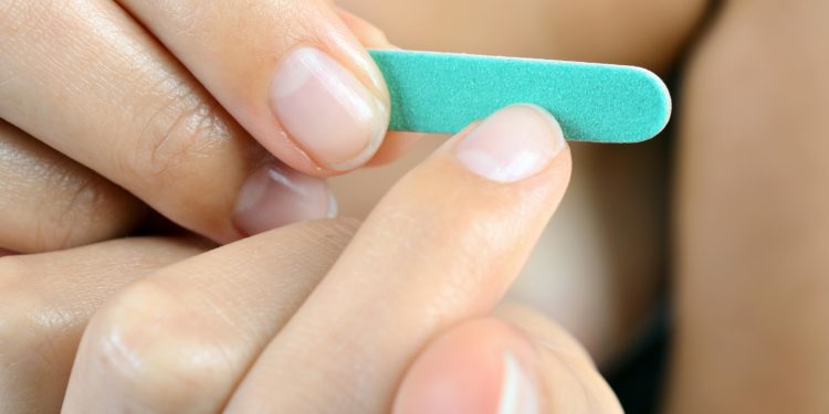 Fingernägel werden mit einer Nagelfeile gefeilt