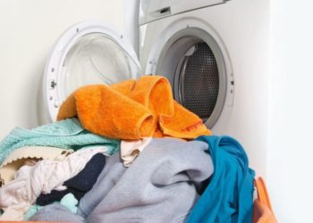 Ein Berg voller Wäsche vor einer geöffneten Waschmaschine