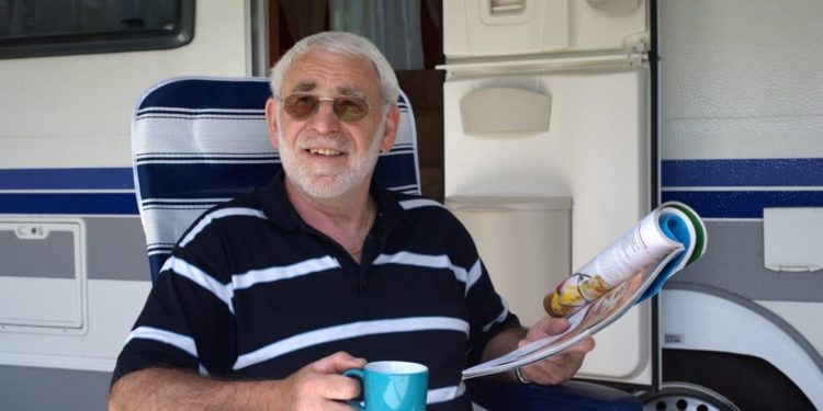 Senior trinkt Kaffee vor seinem Caravan