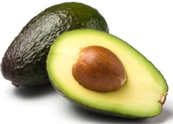 Eine ganze und eine halbe Avocado vor weißem Hintergrund