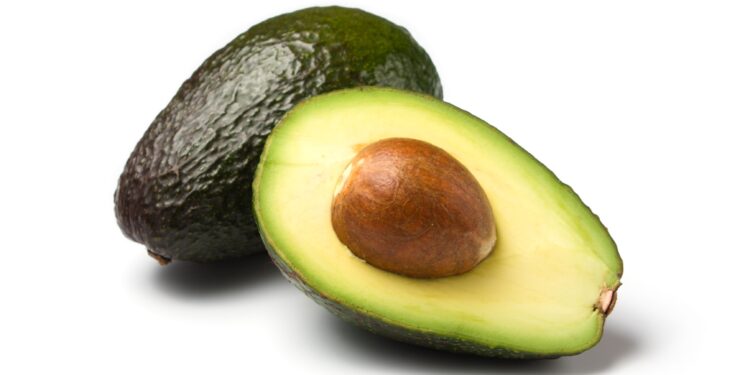 Eine ganze und eine halbe Avocado vor weißem Hintergrund