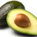 Eine ganze und eine halbe Avocado vor weißem Hintergrund