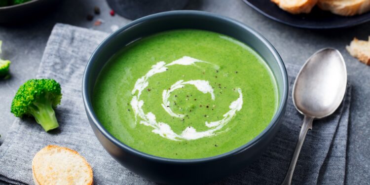 Grüne Brokkoli-Creme-Suppe in schwarzem Suppenteller