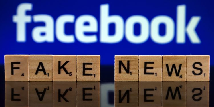 Scrabble Steine mit den Begriffen Fake und News vor dem Schriftzug von Facebook