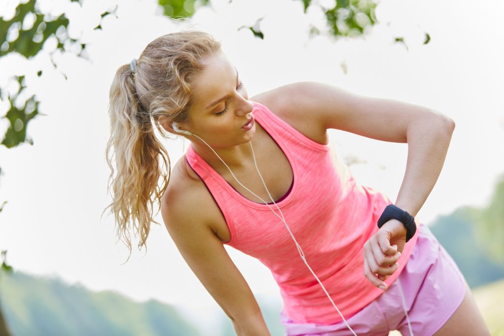 Junge Frau schaut auf ihre Smartwatch